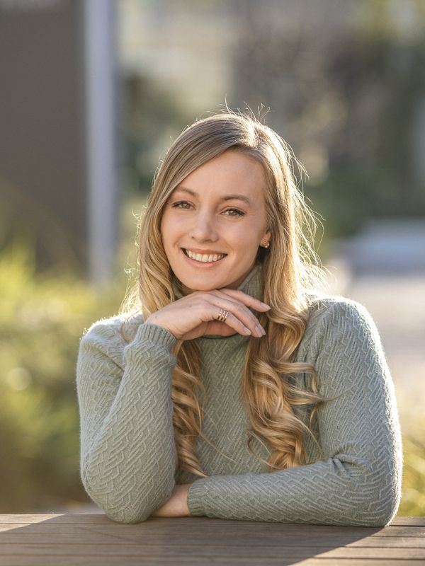 Photos shows the smiling face of Shelby Yaceczko. She is wearing a sage green cable-knit turtleneck sweater.
