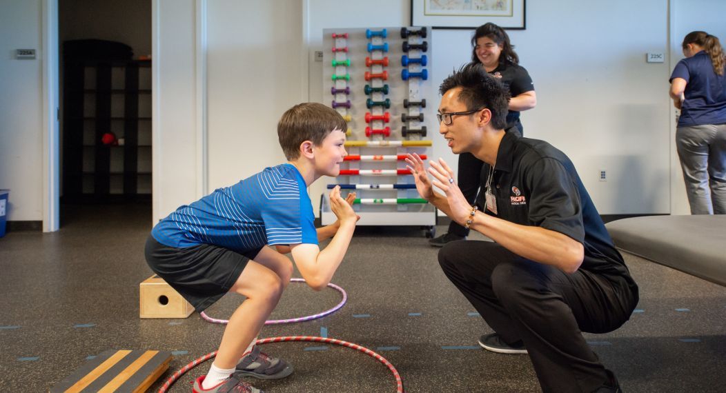 a physical therapy student works with a child during a clinic