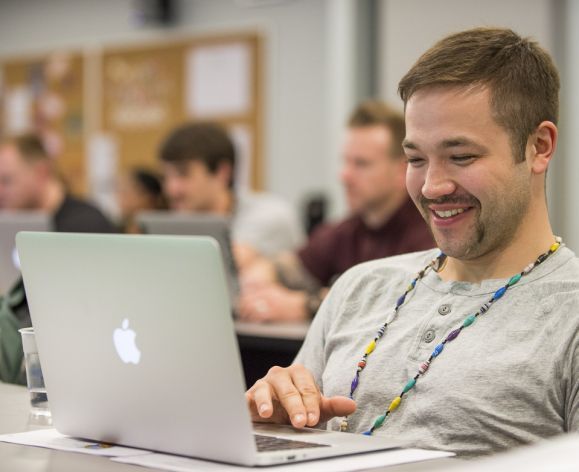 student using laptop and smiling