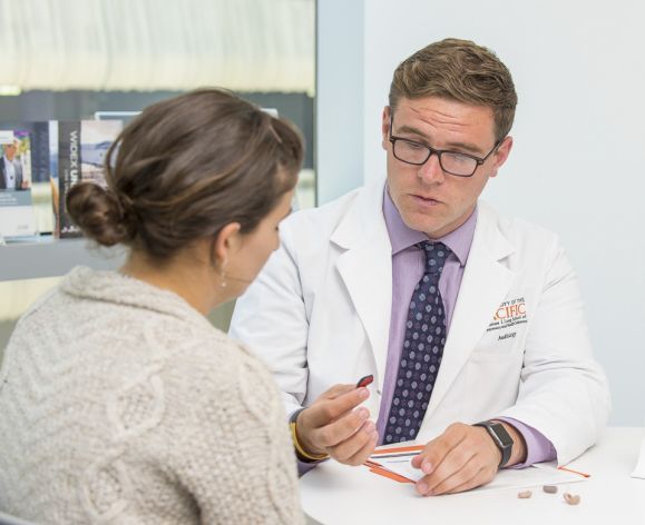 Audiology student holding hearing aids