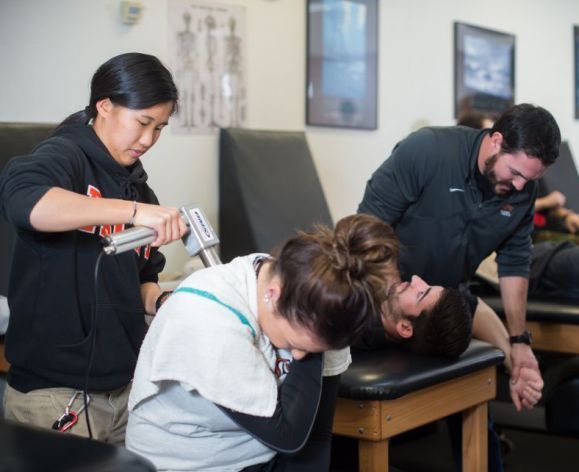 Students administering therapy to athletes